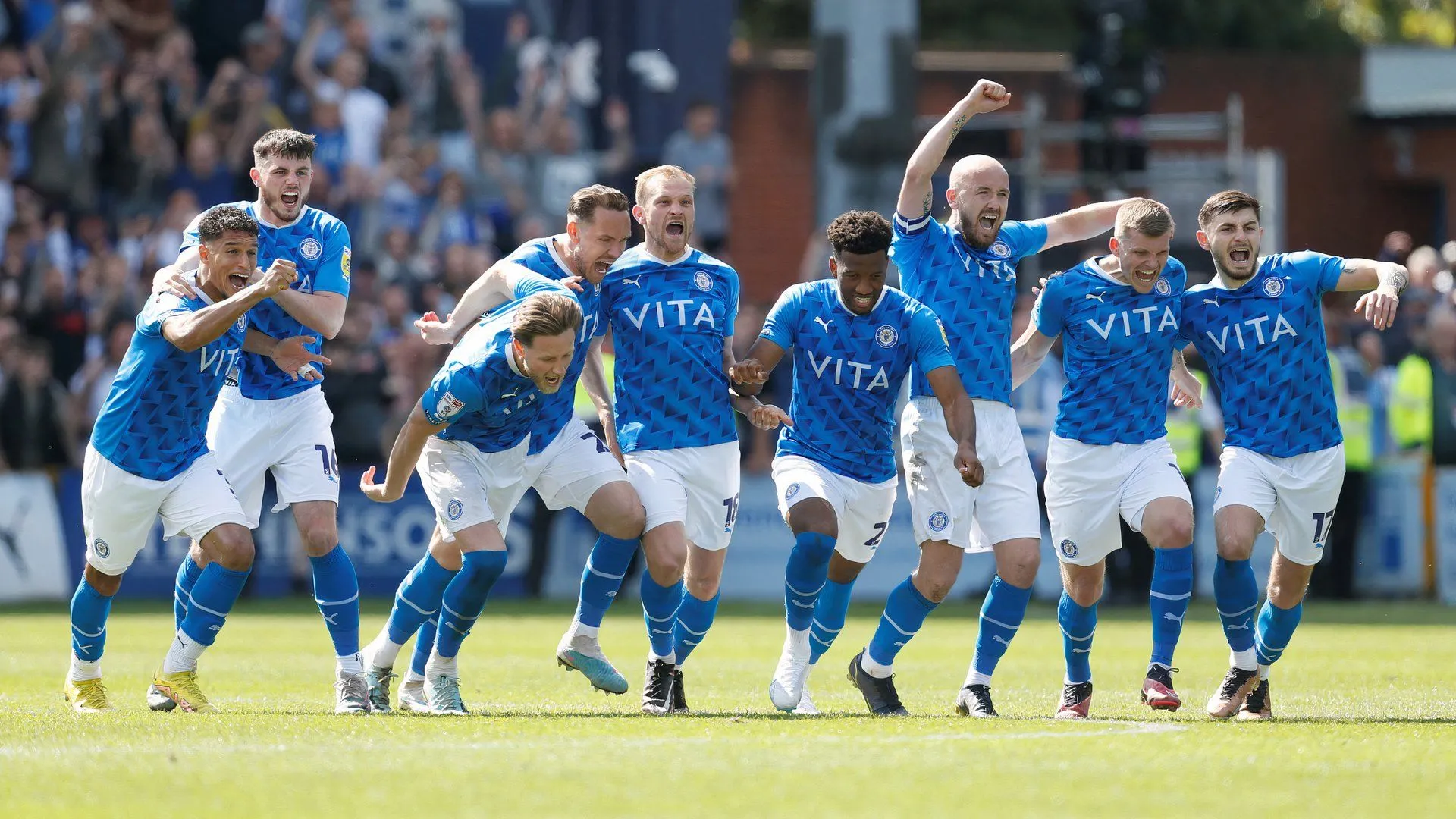 Đội hình Stockport County ăn mừng cuồng nhiệt cùng khán giả nhà sau chiến thắng kịch tính trước Salford City tại bán kết play-off League Two.